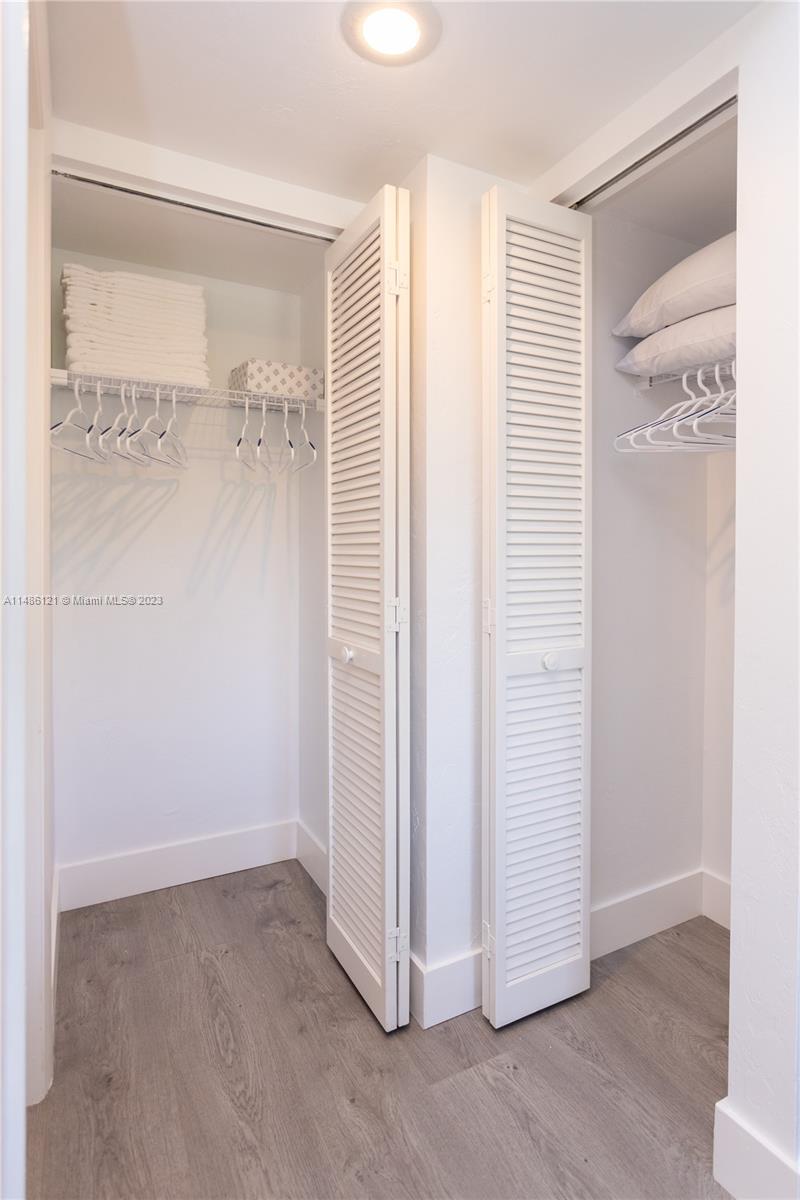 Two white louvered-door closets with wire shelving and wood-look flooring are shown — 500 N Francisco St # 234, Clewiston FL 33440, CLEWISTON, FL