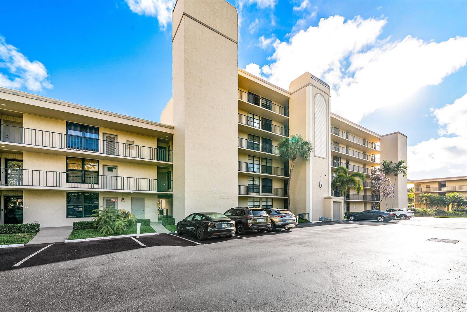 A multi-story apartment building with balconies and a parking lot in front — 6 Royal Palm Way # 605, Boca Raton FL 33432, BOCA RATON, FL