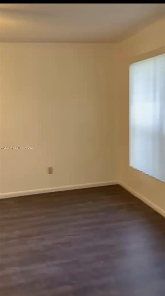 An empty living room features dark wood-look flooring, white walls, a ceiling fan, and blinds — 792 Lantern Tree Ln # 792, Wellington FL 33414, WELLINGTON, FL