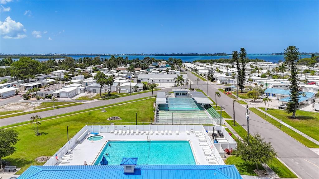 An aerial view shows a swimming pool, tennis courts, and surrounding residential mobile homes — 10315 CORTEZ ROAD W UNIT 58-3, BRADENTON, FL