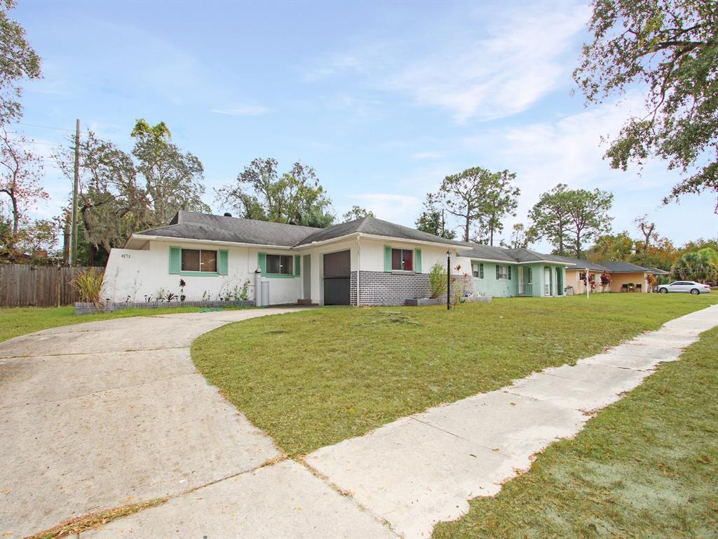 A single-story house with a white exterior, green shutters, and a curved concrete driveway — 4173 SIGNAL HILL ROAD, ORLANDO, FL