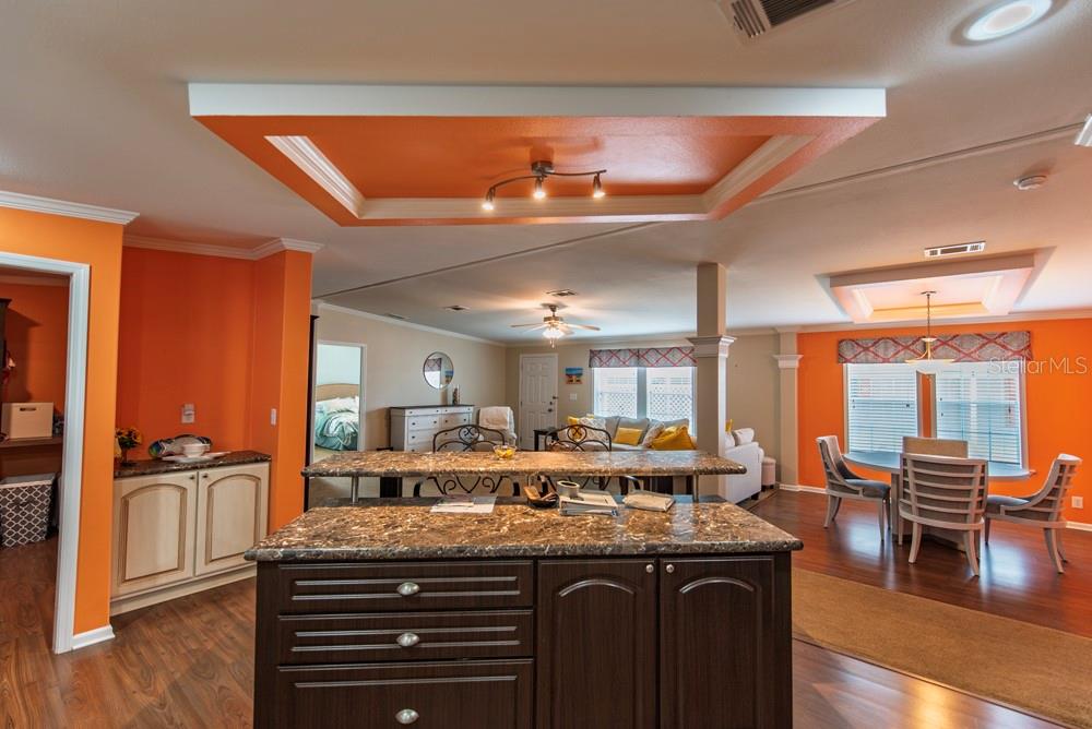 A kitchen island with dark cabinets and granite countertops sits in an open-concept living area — 11 BRINK AVENUE, PUNTA GORDA, FL