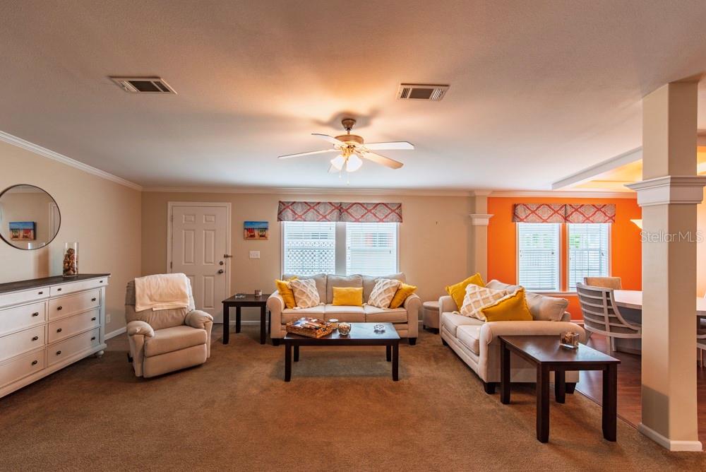 A living room features beige carpet, two sofas, a recliner, and an orange accent wall — 11 BRINK AVENUE, PUNTA GORDA, FL