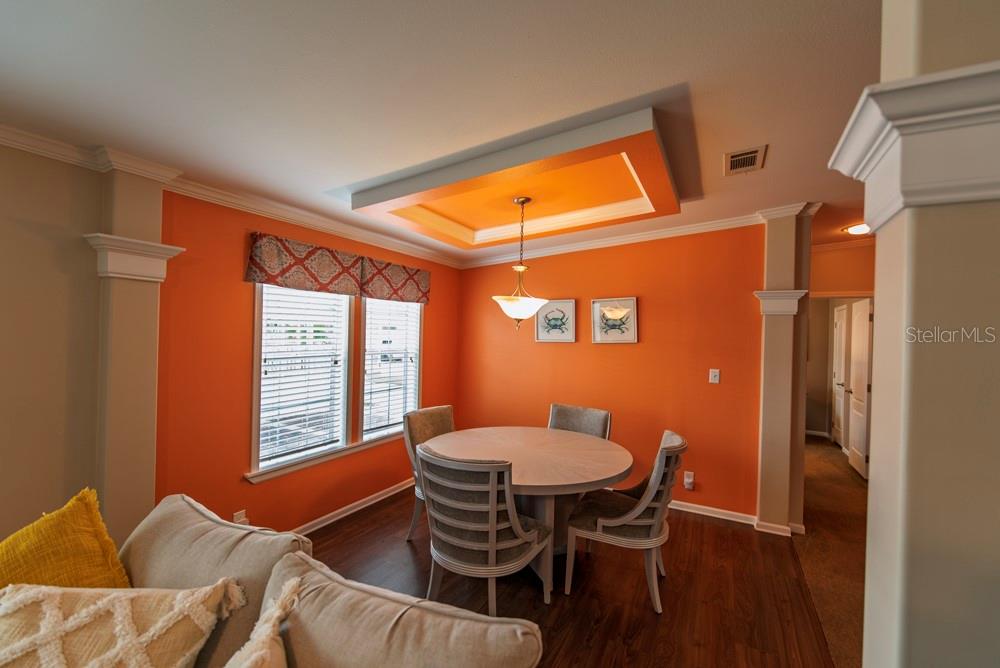 A dining area features orange walls, a tray ceiling, a round table, and four chairs — 11 BRINK AVENUE, PUNTA GORDA, FL