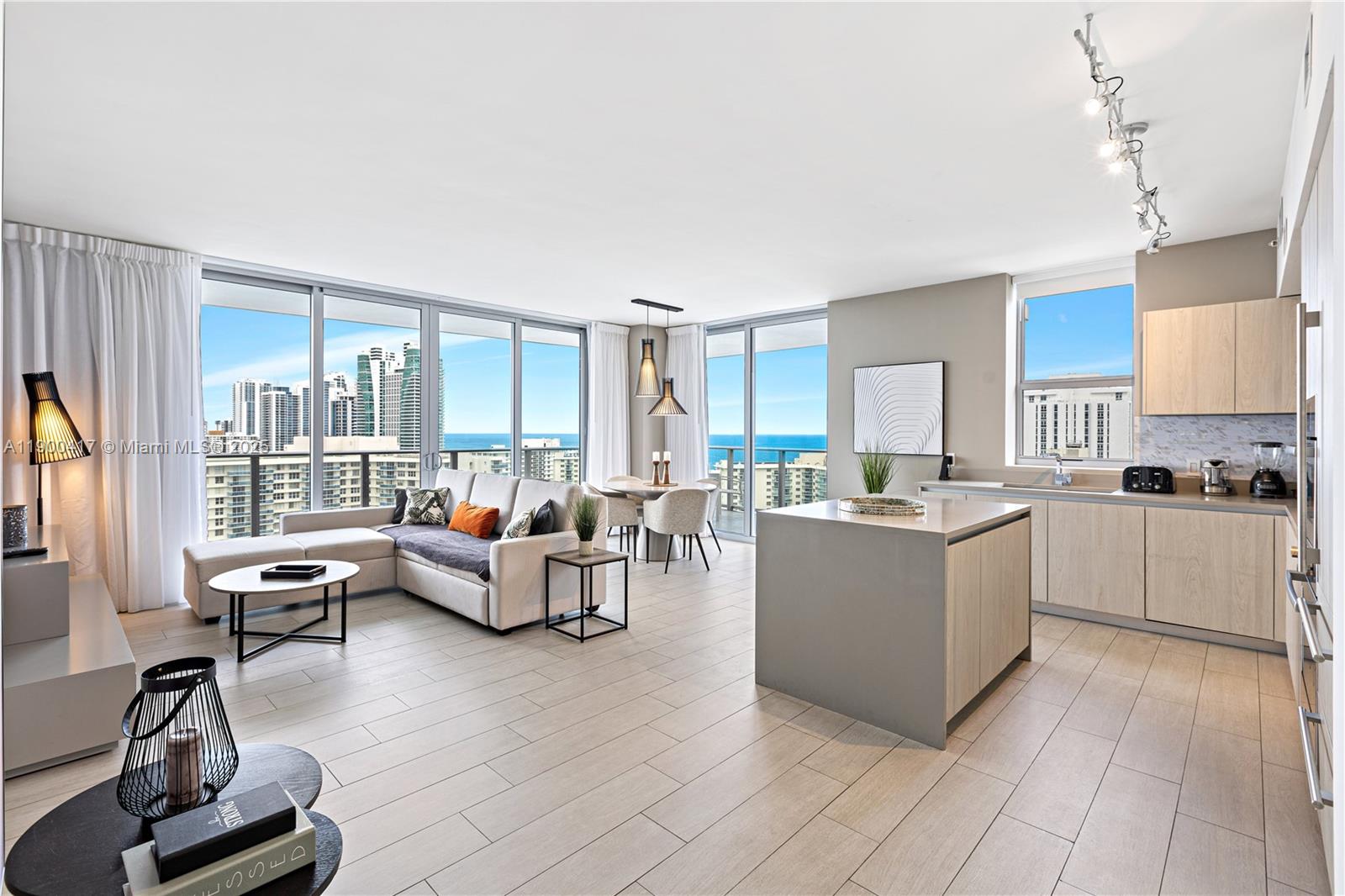 An open-concept living and kitchen area features light wood cabinetry, tile flooring, and ocean views — 4010 S Ocean Dr # R1701, Hollywood FL 33019, HOLLYWOOD, FL