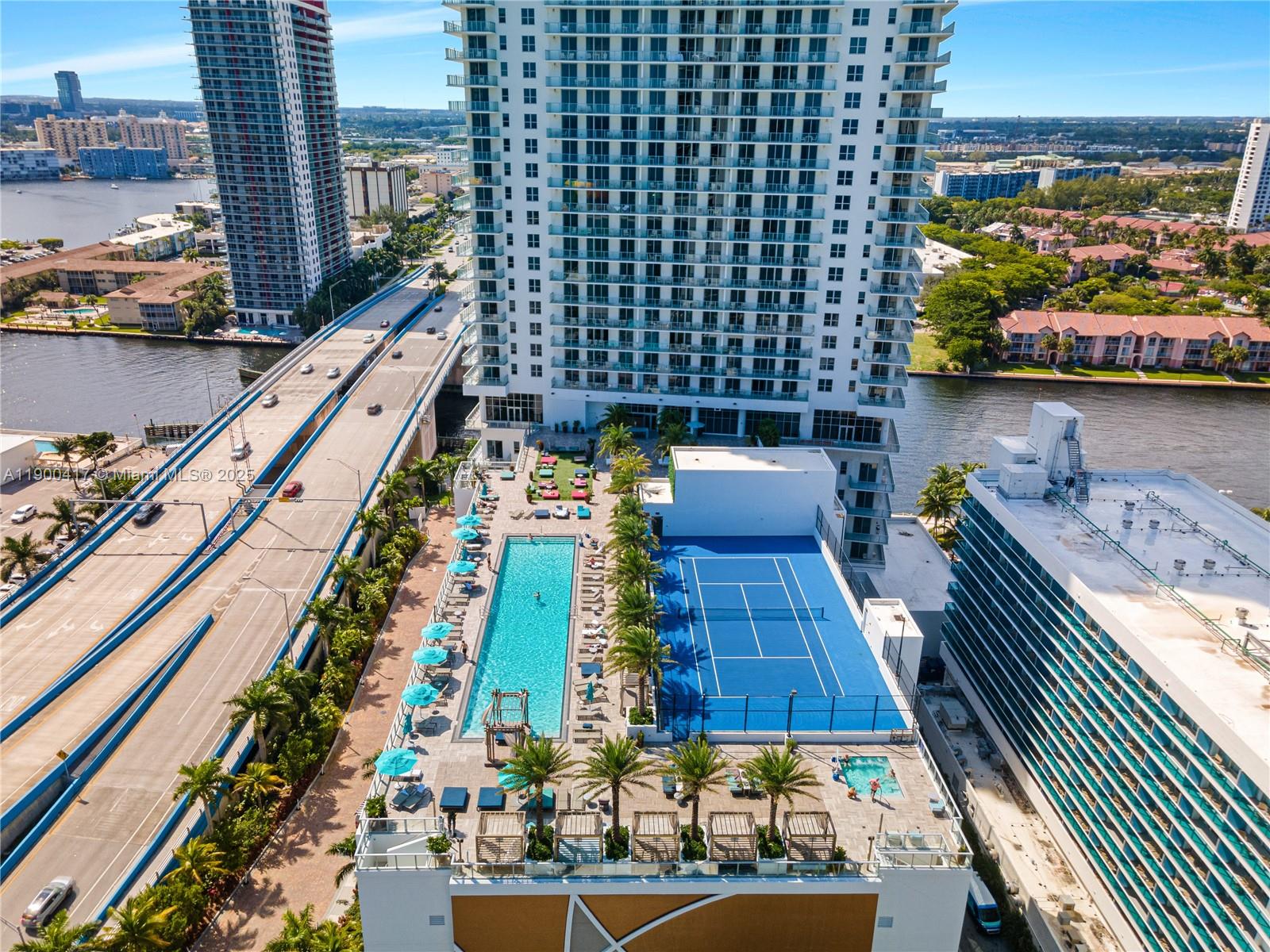 An aerial view shows a high-rise building with a pool deck and tennis court — 4010 S Ocean Dr # R1701, Hollywood FL 33019, HOLLYWOOD, FL