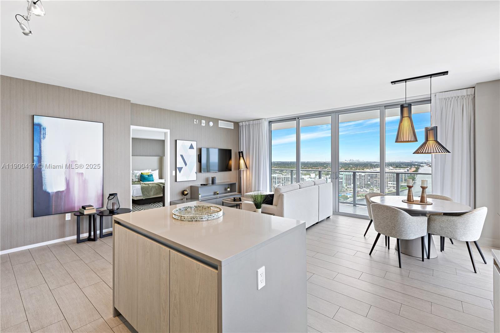 A modern open-concept living and dining area features a kitchen island, balcony, and city views — 4010 S Ocean Dr # R1701, Hollywood FL 33019, HOLLYWOOD, FL
