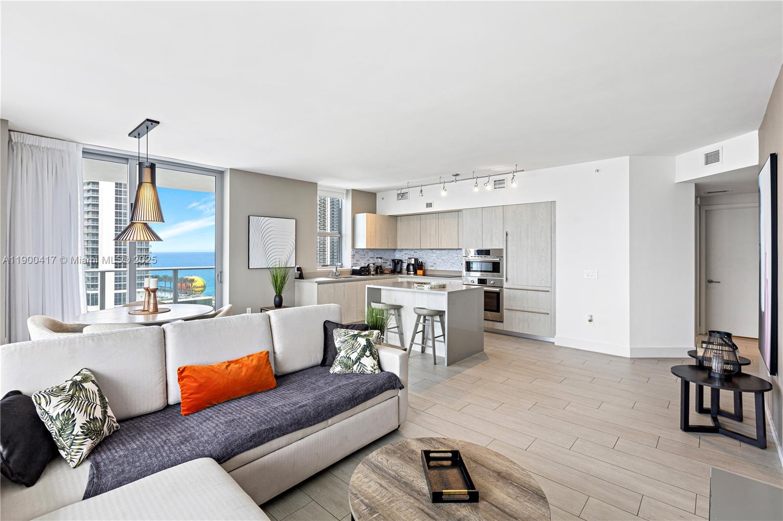 An open-concept living area features a kitchen with light wood cabinetry and ocean views — 4010 S Ocean Dr # R1701, Hollywood FL 33019, HOLLYWOOD, FL