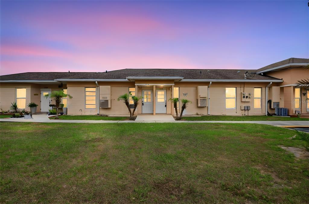 A single-story tan building with two central white doors and a grassy front lawn — 2629 CLUB CIRCLE UNIT 2629, LAKE WALES, FL