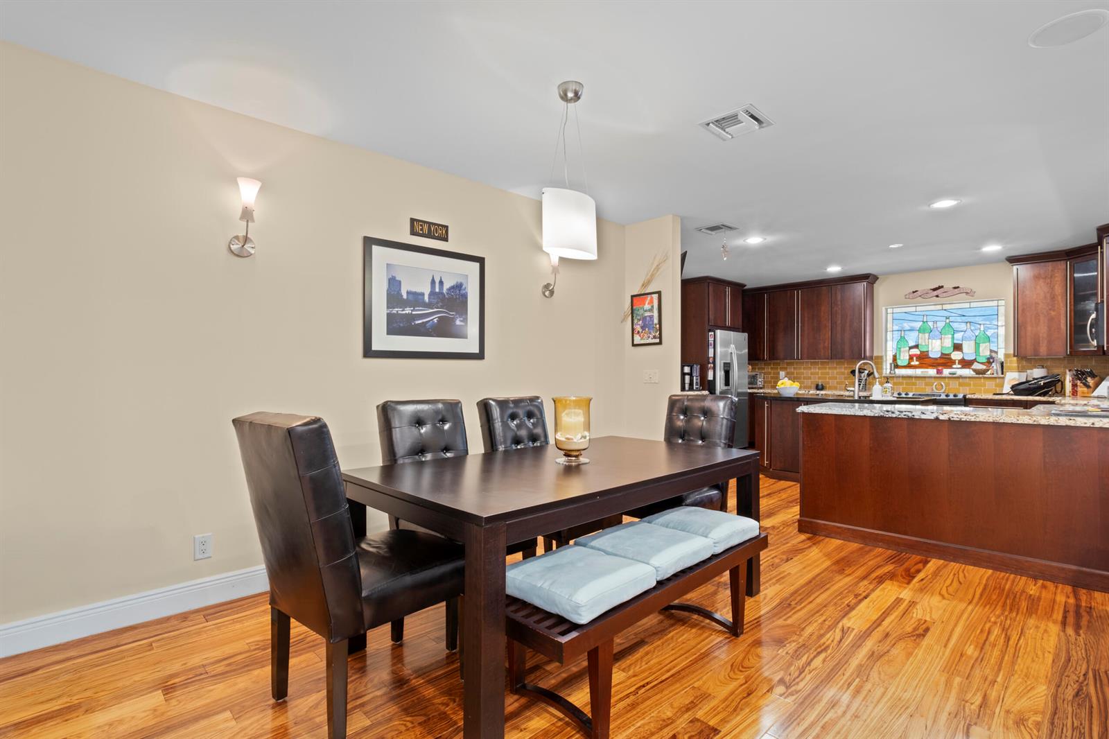A dining area with a dark wood table and chairs sits adjacent to a kitchen — 2700 NE 4th Way, Boca Raton FL 33431, BOCA RATON, FL