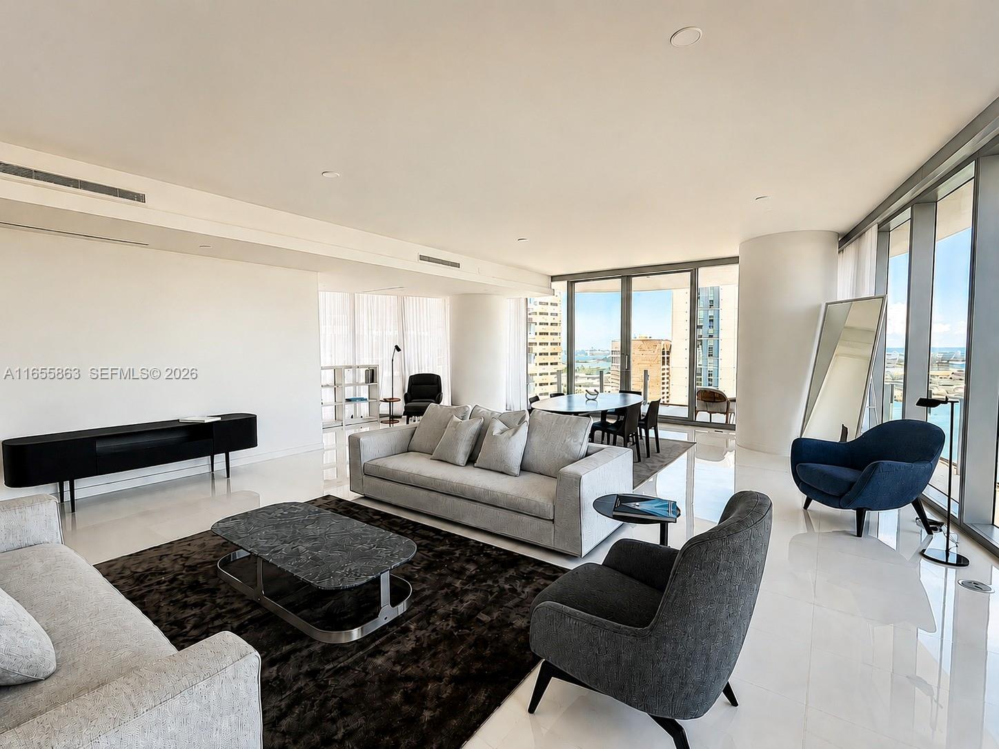 A modern living room features white tile floors, a grey sofa, and floor-to-ceiling windows — 300 Biscayne Blvd Way # 3201, Miami FL 33131, MIAMI, FL