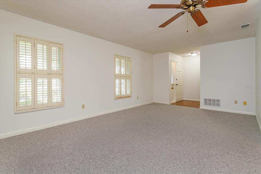 A carpeted room with white walls, plantation shutters, and a ceiling fan — 1192 LADY SUSAN DRIVE, CASSELBERRY, FL
