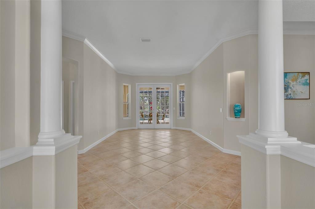 An entryway features tile flooring, white columns, and double glass doors leading to the outdoors — 1800 MAGNOLIA AVENUE, WINTER PARK, FL