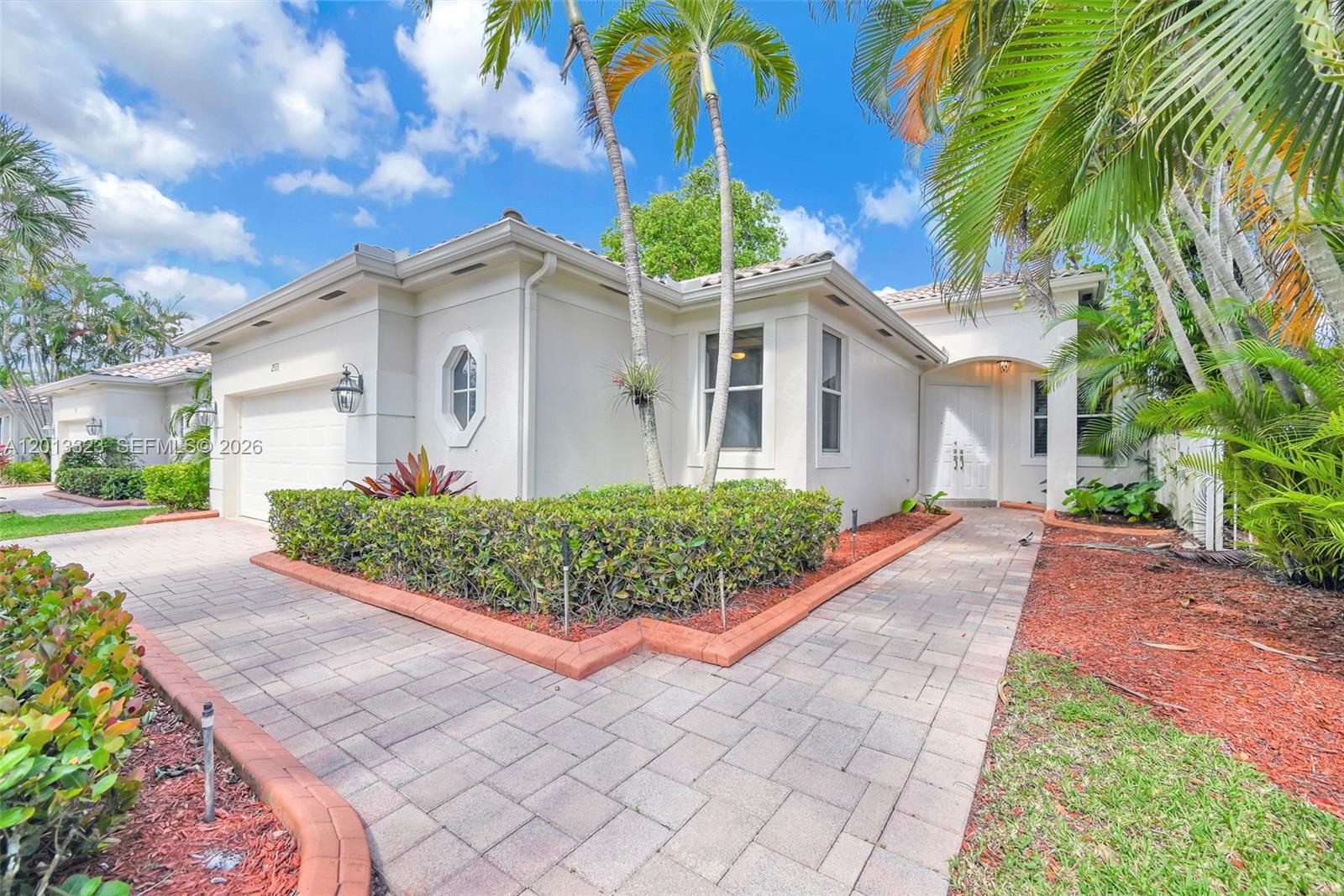 A single-story house with a paved driveway, a manicured hedge, and palm trees — 2553 Bay Pointe Drive, Weston FL 33327, WESTON, FL