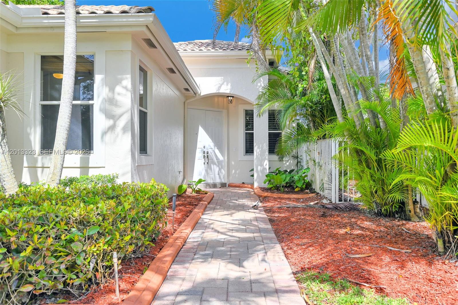 A paved walkway leads to the white double front doors of a stucco house — 2553 Bay Pointe Drive, Weston FL 33327, WESTON, FL