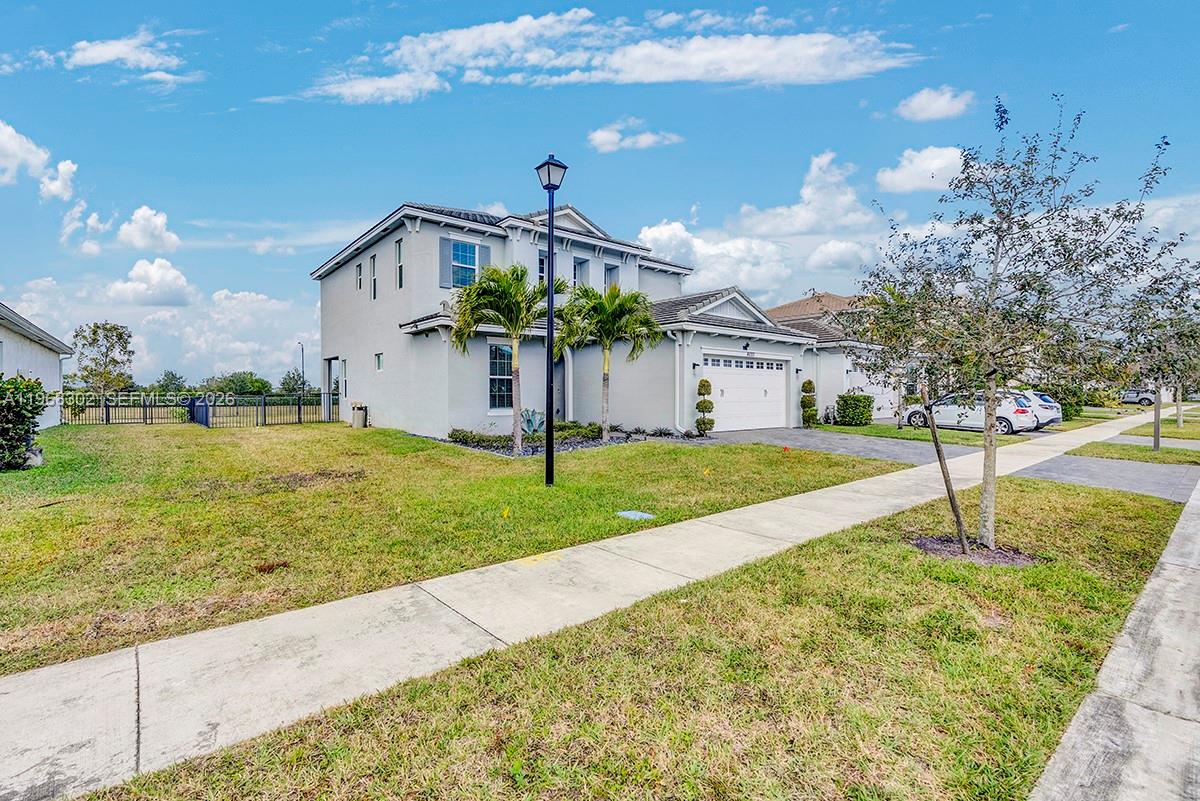 A two-story suburban house with a two-car garage, palm trees, and a front lawn — 4655 Citron Way, Westlake FL 33470, WESTLAKE, FL