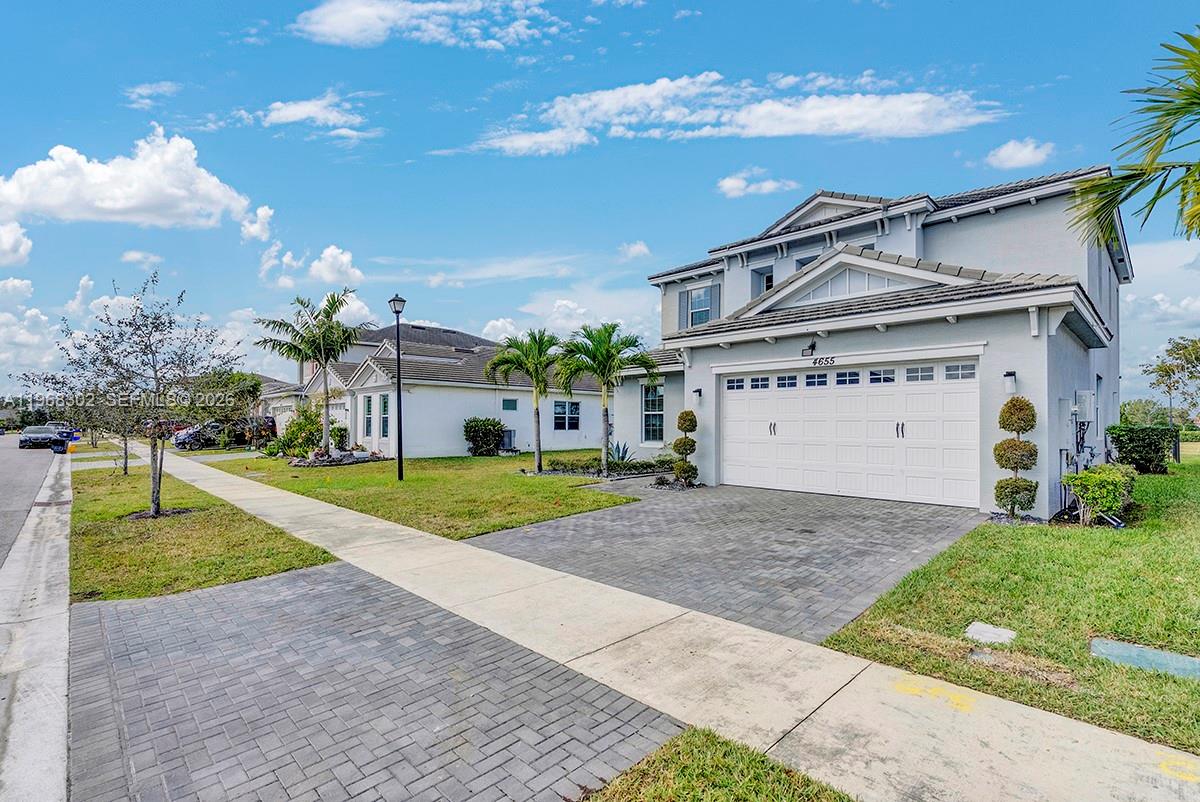 A two-story suburban house with a white garage and a paved driveway under a blue sky — 4655 Citron Way, Westlake FL 33470, WESTLAKE, FL