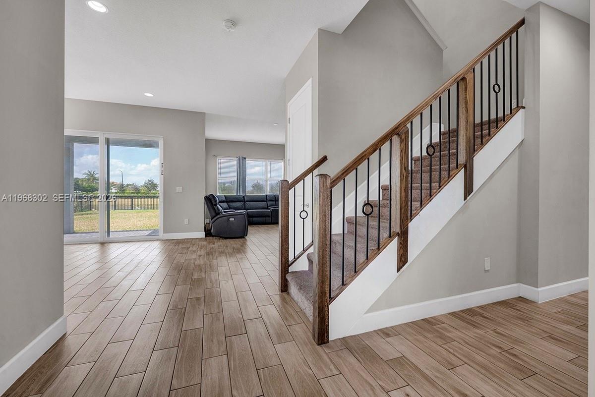 An interior view shows a staircase with wood railings and tile flooring leading to a living area — 4655 Citron Way, Westlake FL 33470, WESTLAKE, FL