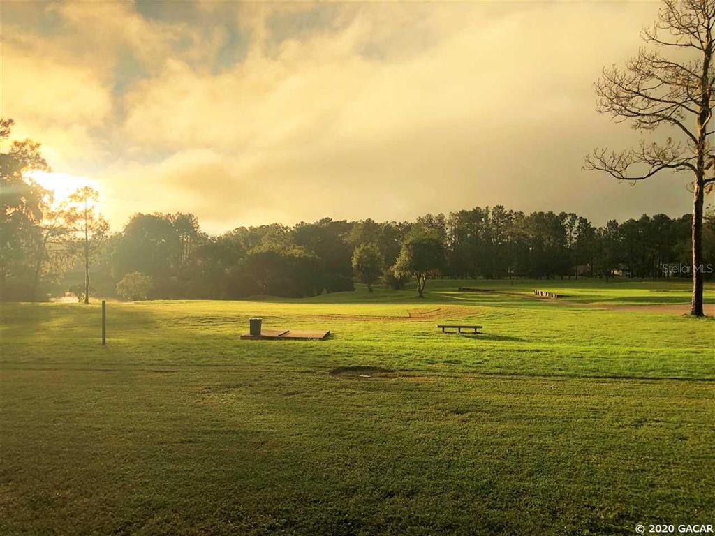 A grassy field with scattered trees under a bright, cloudy sky at sunset — 000 NW 105TH AVENUE, ALACHUA, FL