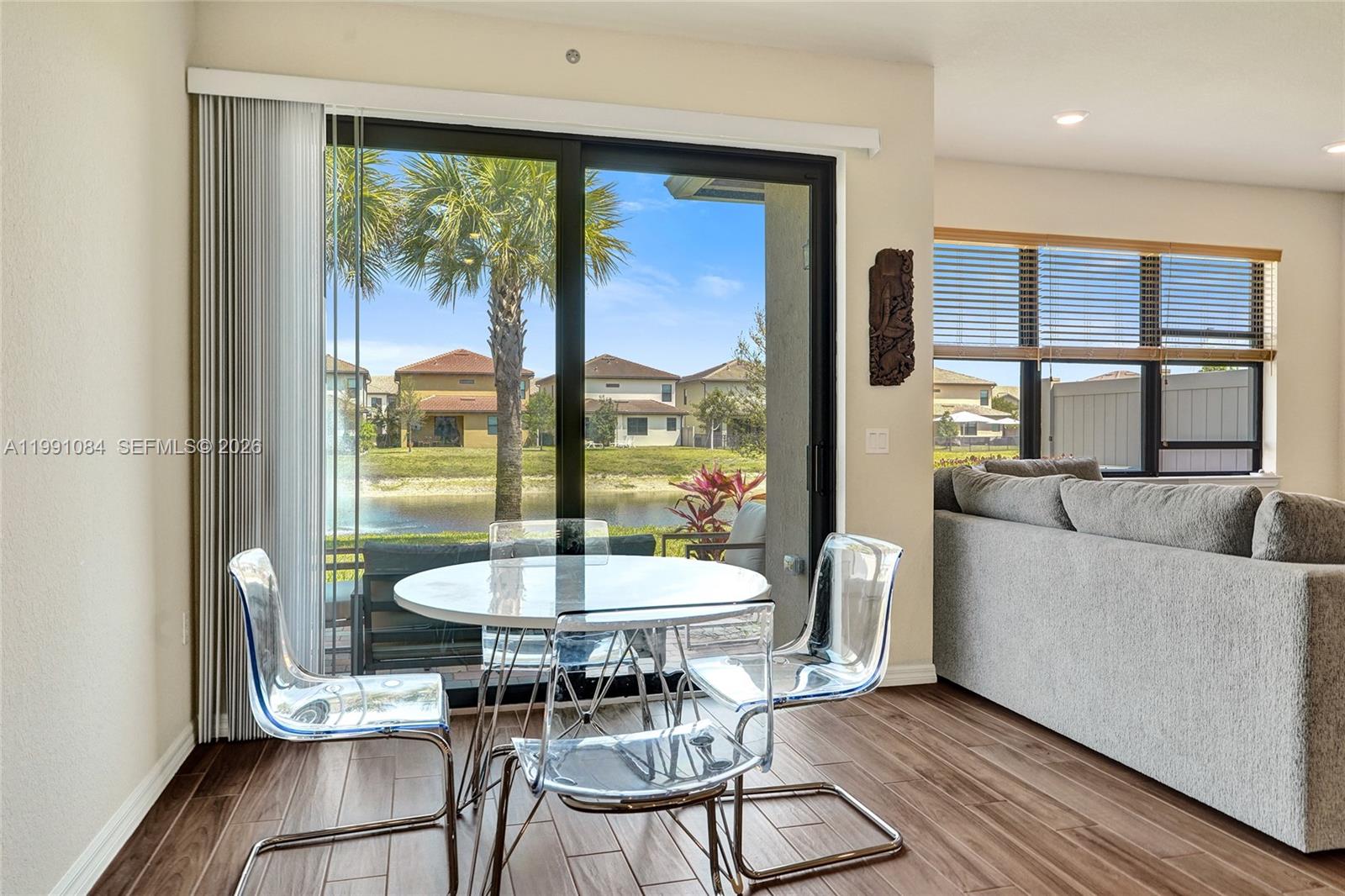 A dining area features a glass table with clear chairs beside a sliding glass door — 4814 Jumping Way, Lake Worth FL 33467, LAKE WORTH, FL