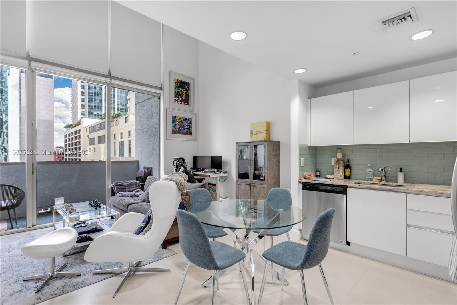 A modern apartment features a kitchen, dining area, and living space with floor-to-ceiling windows — 1060 Brickell Ave # 409, Miami FL 33131, MIAMI, FL