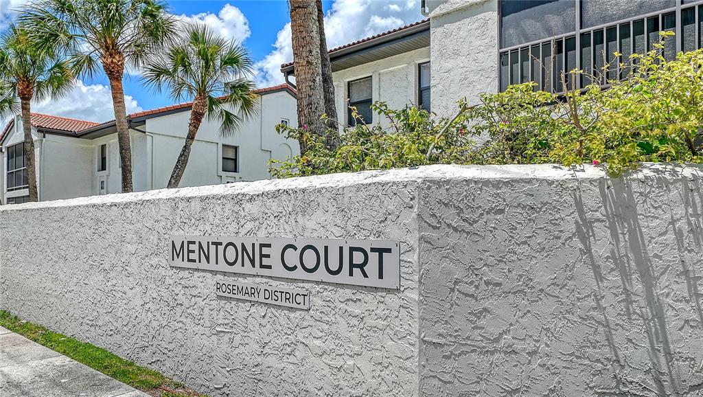 A white stucco wall displays a sign for Mentone Court in front of residential buildings — 631 N ORANGE AVENUE UNIT 108, SARASOTA, FL