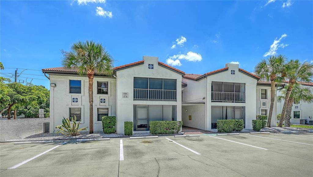 A two-story apartment building with a parking lot in front and palm trees — 631 N ORANGE AVENUE UNIT 108, SARASOTA, FL