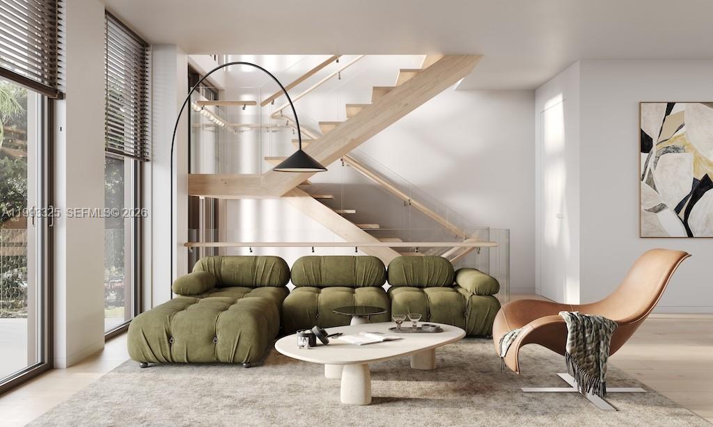 This rendering shows a modern living room with a green sofa, lounge chair, and wooden staircase — 1709 Jefferson Ave # 10, Miami Beach FL 33139, MIAMI BEACH, FL
