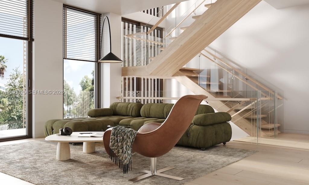 This rendering shows a modern living room with a green sofa, brown chair, and wooden staircase — 1709 Jefferson Ave # 10, Miami Beach FL 33139, MIAMI BEACH, FL