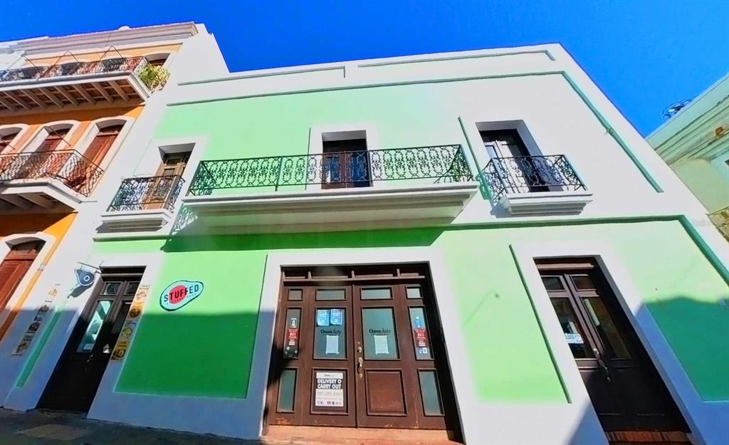 A two-story building with a light green facade, dark wood doors, and a wrought-iron balcony — 209 SAN FRANCISCO STREET, SAN JUAN, PR