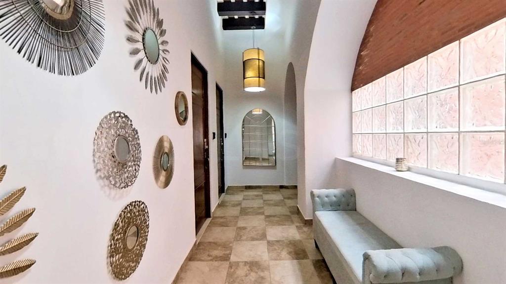 A hallway features tiled floors, a tufted bench, glass block windows, and decorative wall mirrors — 209 SAN FRANCISCO STREET, SAN JUAN, PR