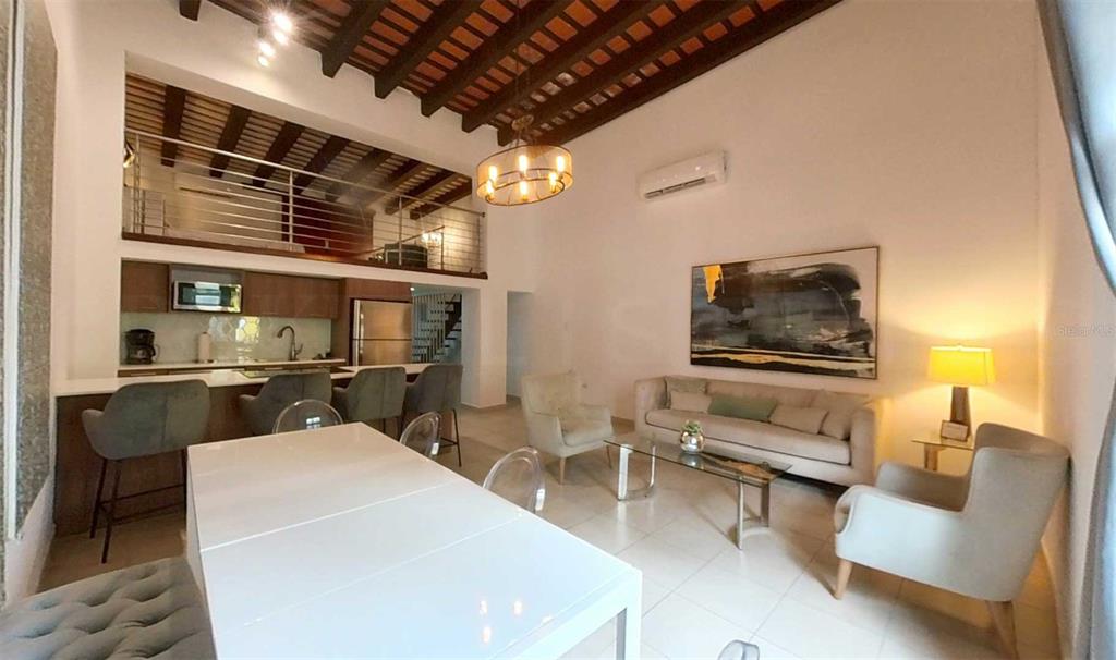 A modern open-concept living and dining area features a lofted space, exposed wood beams, and tile — 209 SAN FRANCISCO STREET, SAN JUAN, PR