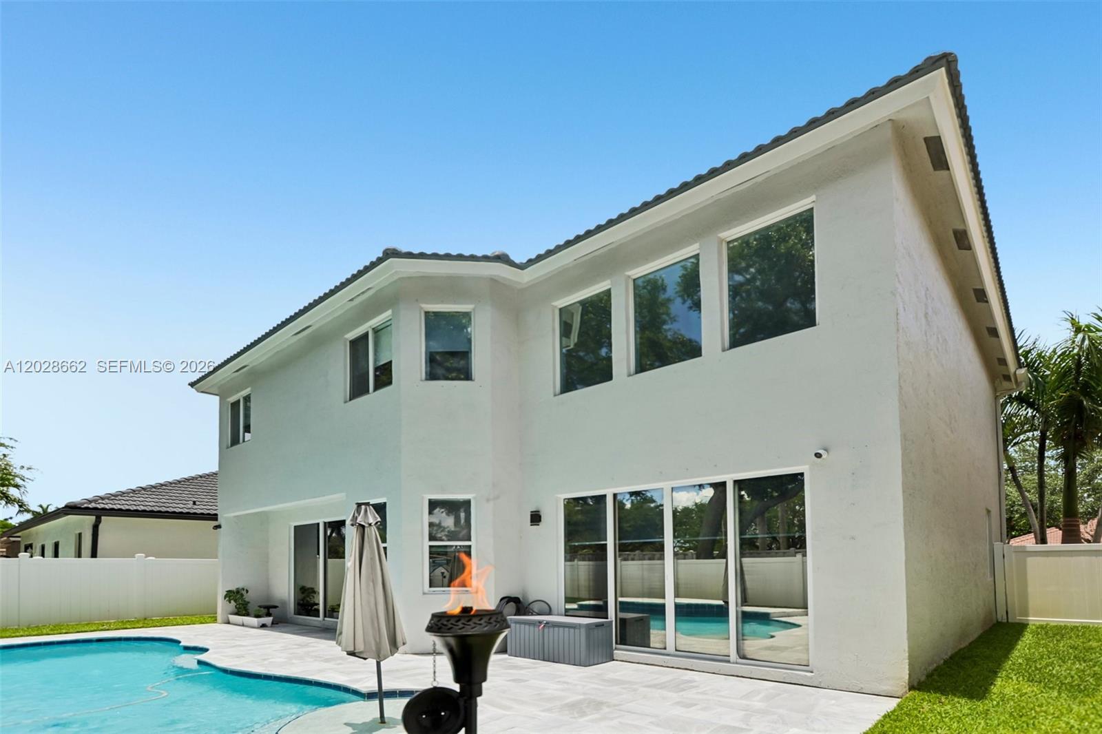 The exterior of a two-story white house features a swimming pool and a patio — 13370 SW 32nd St, Miramar FL 33027, MIRAMAR, FL