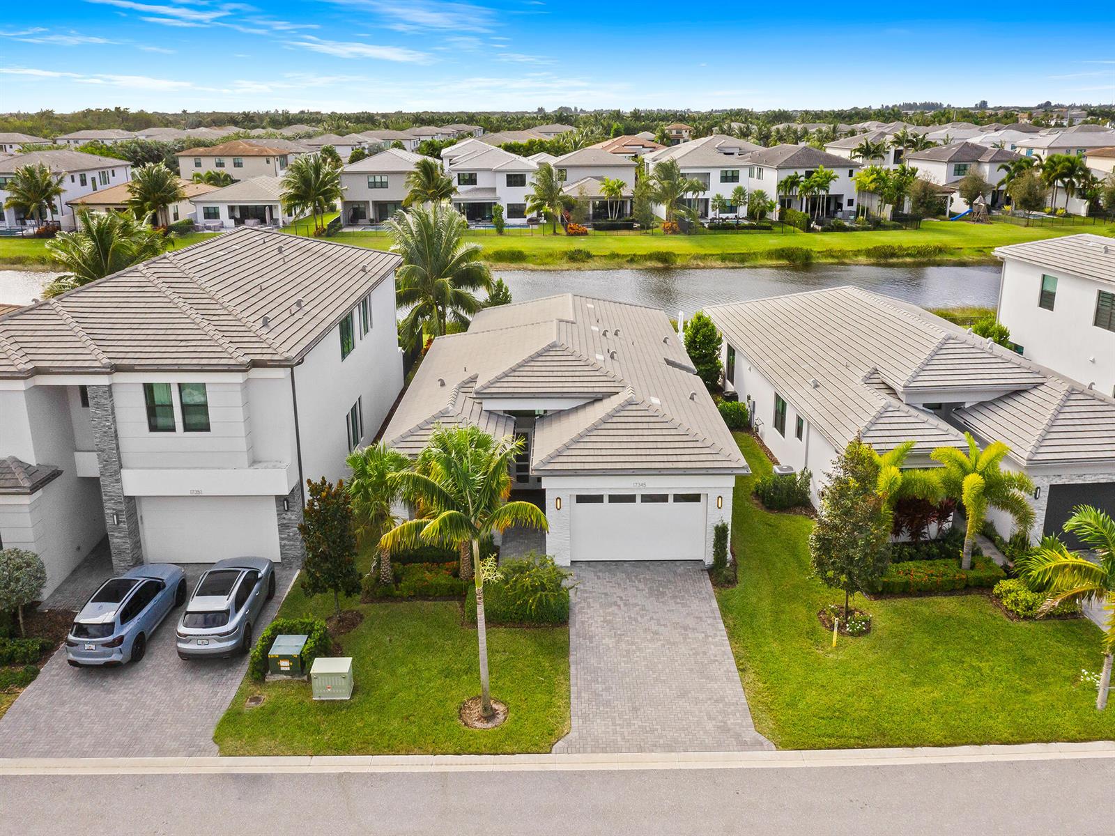 An aerial view shows three suburban houses with tiled roofs, driveways, and palm trees — 17345 Sea Blossom Way, Boca Raton FL 33496, BOCA RATON, FL