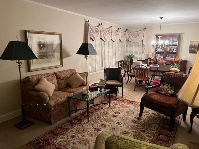A living room features a patterned sofa, two armchairs, a dining set, and a rug — 1628 NW 6TH AVENUE, GAINESVILLE, FL