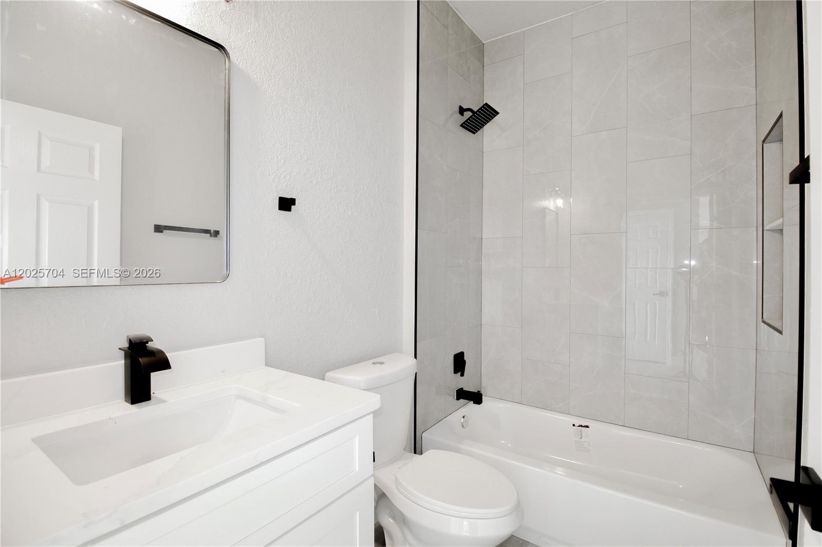 A modern kitchen features white cabinets, stainless steel appliances, a white island, and pendant lighting — 4608 CORTEZ BLVD, Sebring FL 33872, SEBRING, FL
