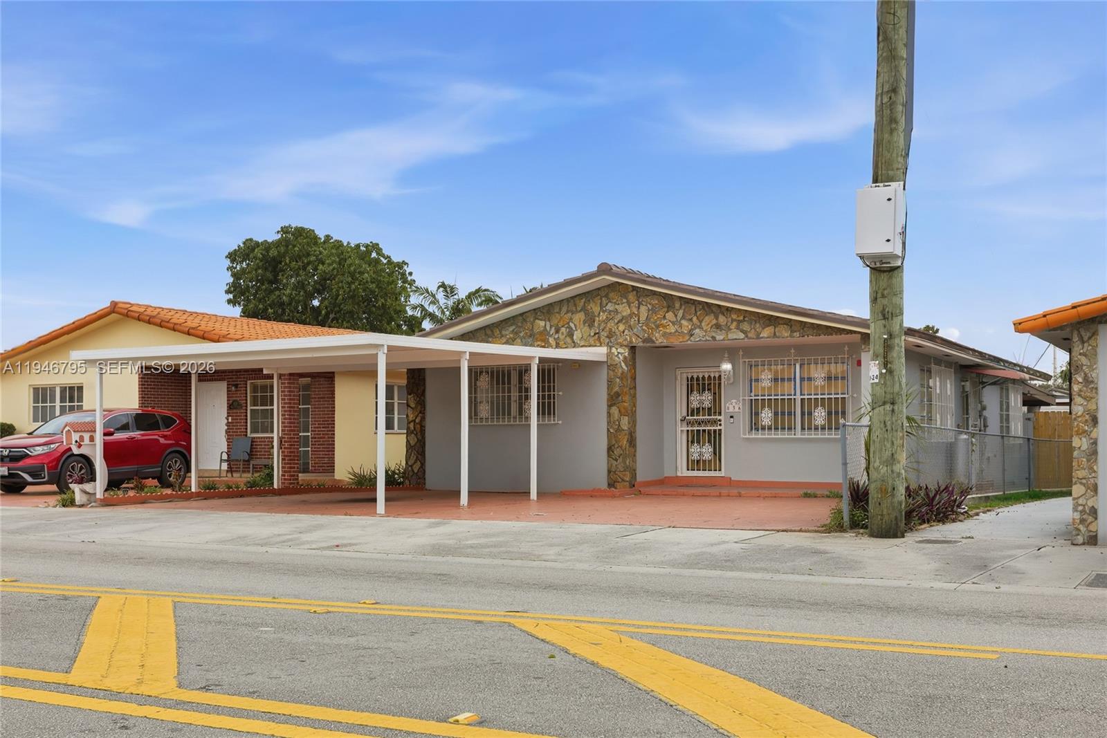 A single-story house with a stone facade, a carport, and security bars on the windows — 836 W 37th St, Hialeah FL 33012, HIALEAH, FL