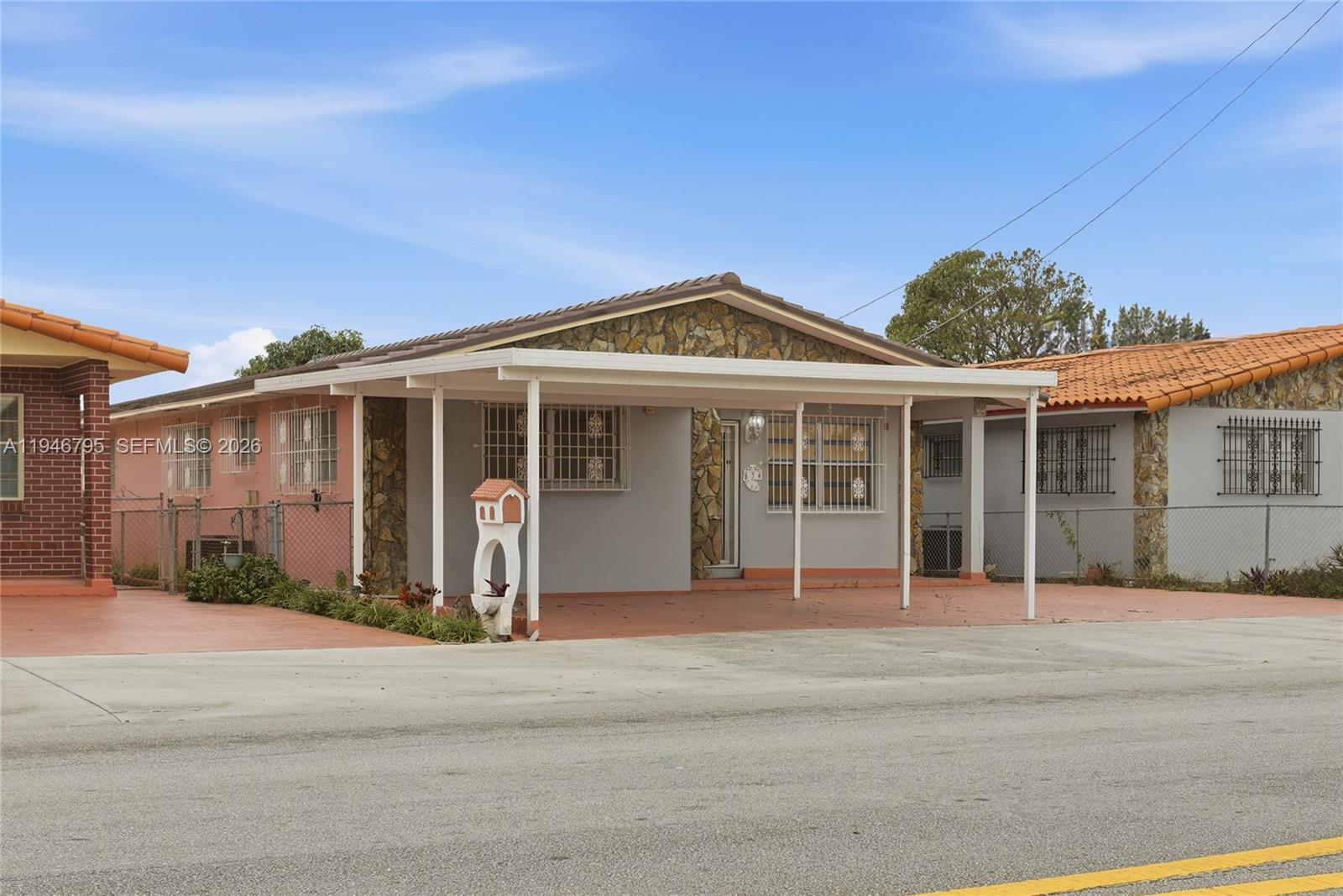 A single-story house with a stone facade, a carport, and security bars on the windows — 836 W 37th St, Hialeah FL 33012, HIALEAH, FL