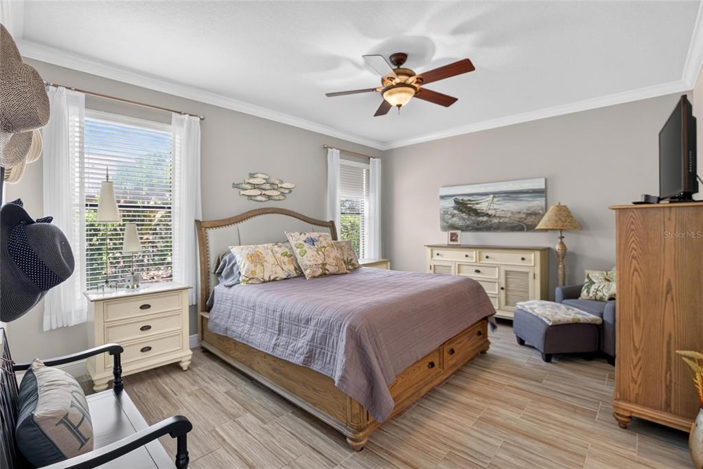 A bedroom features a wooden bed frame, tile flooring, a ceiling fan, and two windows — 342 BLUEWATER FALLS COURT, APOLLO BEACH, FL