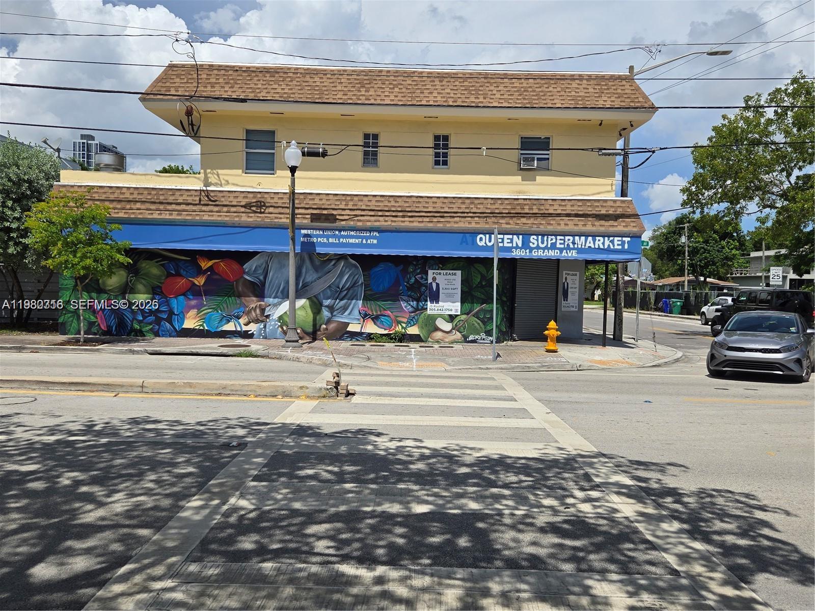 A two-story yellow building with a colorful mural and a blue awning on a corner — 3380 Plaza St, Miami FL 33133, MIAMI, FL