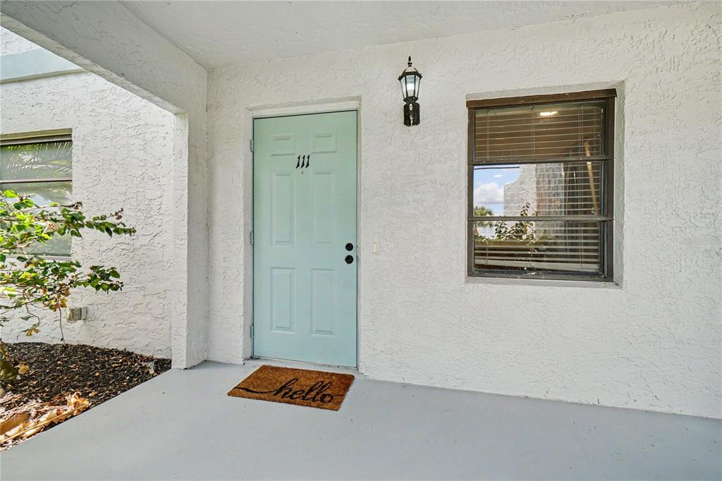 A light blue front door with the number 111 sits on a covered concrete porch — 3627 BAL HARBOR BOULEVARD UNIT 111, PUNTA GORDA, FL