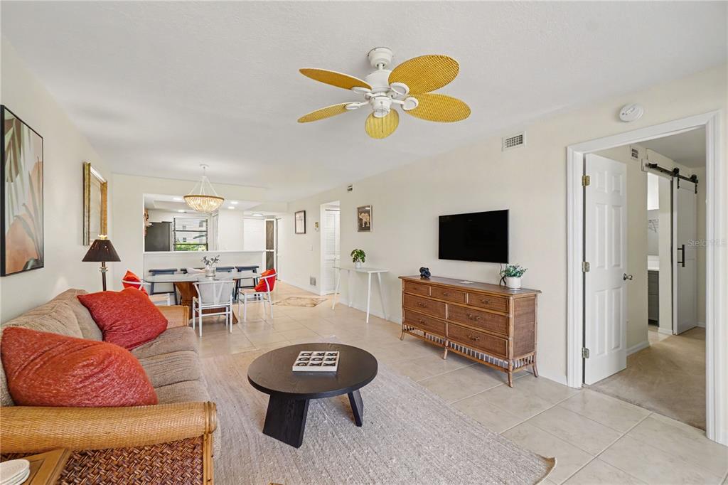 A living room features a tan sofa, a round coffee table, and a wooden dresser — 3627 BAL HARBOR BOULEVARD UNIT 111, PUNTA GORDA, FL