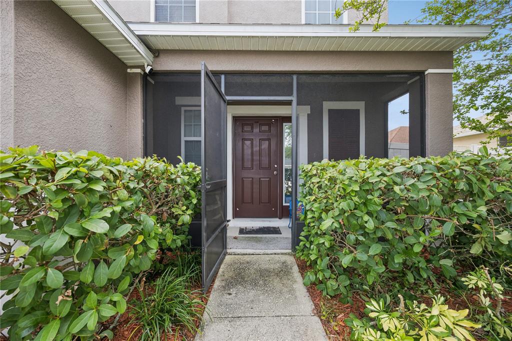 A two-story suburban house with a two-car garage, tan stucco siding, and a front lawn — 5170 PRESERVE BOULEVARD, ST CLOUD, FL