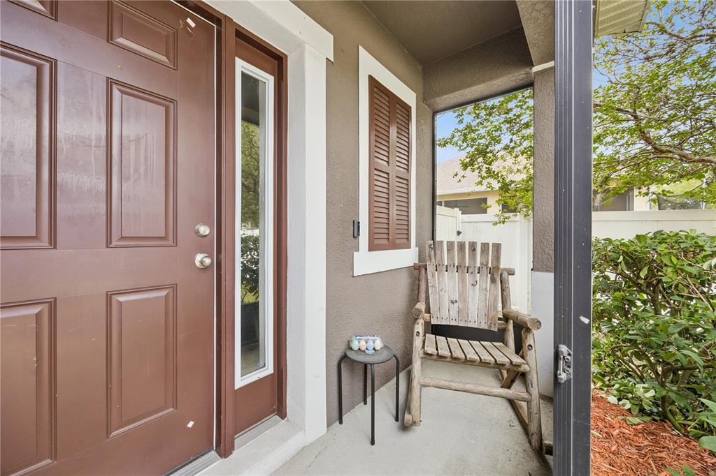A concrete walkway leads to a brown front door enclosed by a screened-in porch area — 5170 PRESERVE BOULEVARD, ST CLOUD, FL