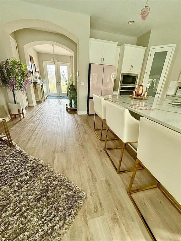 A kitchen features a pink refrigerator, white cabinetry, and a marble-topped island with bar stools — 2667 NORTHWOOD PARK STREET, VALRICO, FL