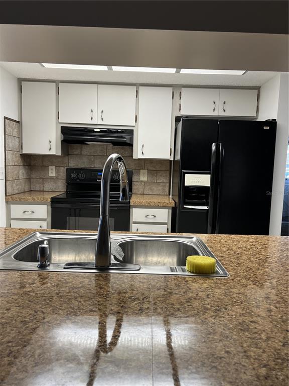 A kitchen features white cabinets, black appliances, a double sink, and speckled brown countertops — 4813 DOGWOOD STREET, NEW PORT RICHEY, FL