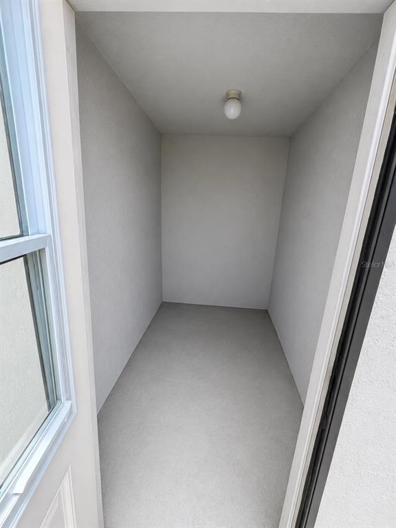 A small, empty storage closet with light gray walls, a concrete floor, and a ceiling light — 3019-3019 WALNUT COURT, LEESBURG, FL