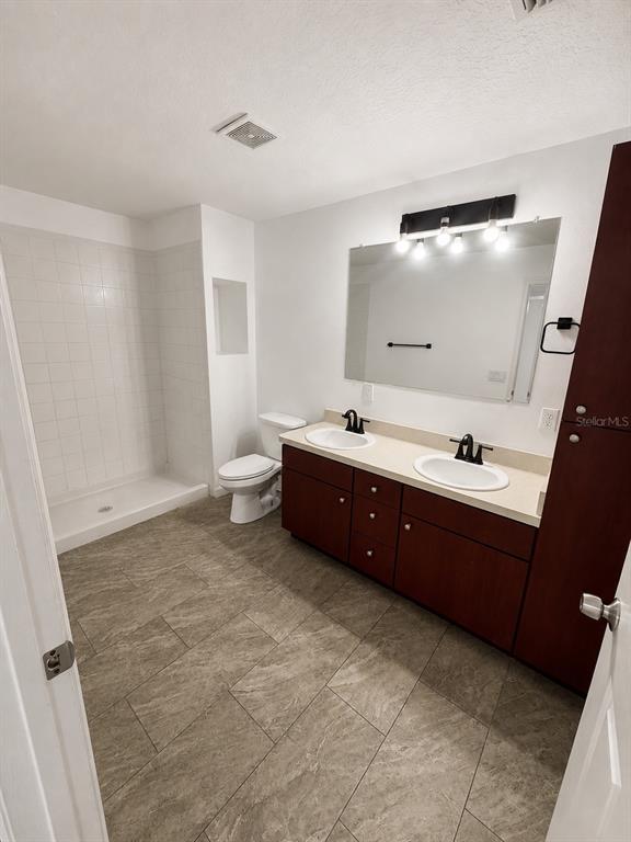 A bathroom features a double-sink vanity, a walk-in shower, and tile flooring — 3019-3019 WALNUT COURT, LEESBURG, FL