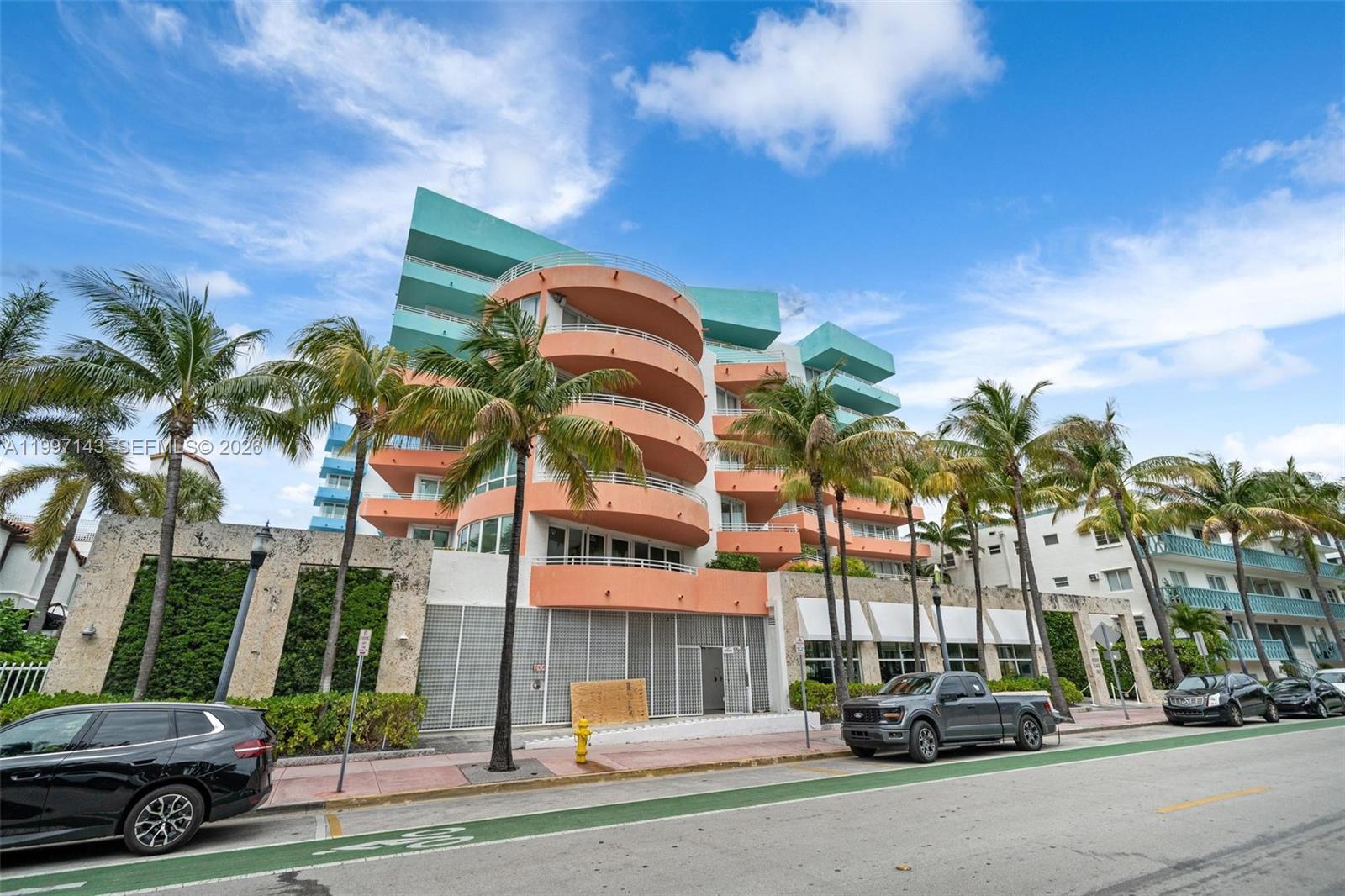 A multi-story building with peach-colored curved balconies and teal accents stands above a street — 226 Ocean Dr # 8F, Miami Beach FL 33139, MIAMI BEACH, FL