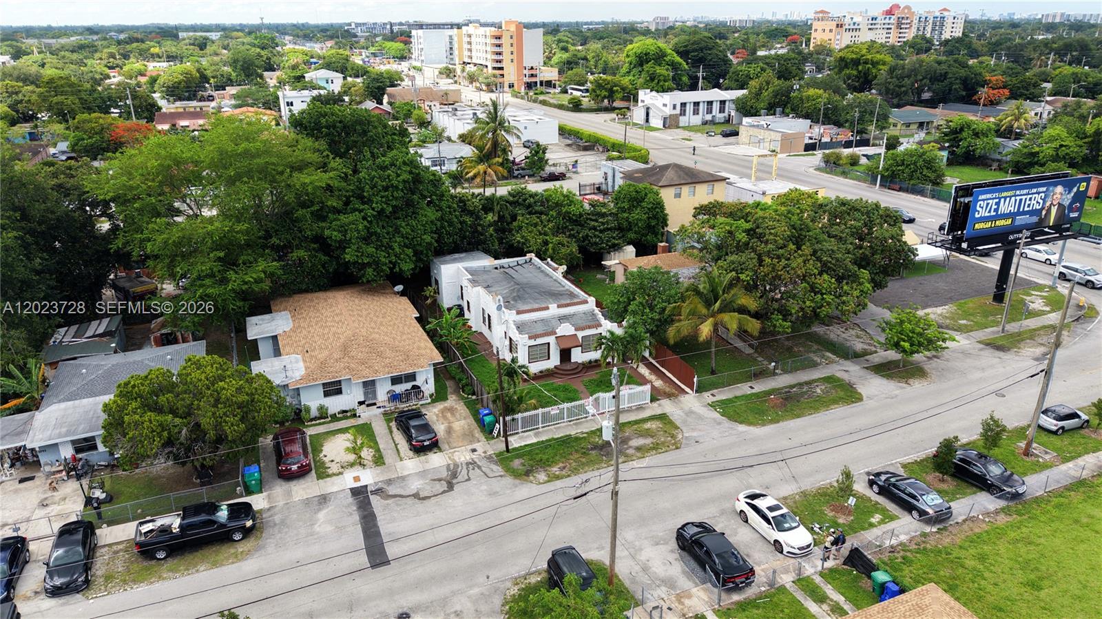 An aerial view shows two adjacent houses with driveways and parked cars on a street — 1727 NW 50th St, Miami FL 33142, MIAMI, FL